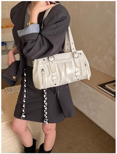 Détail du sac à bandoulière plissé blanc en cuir brillant avec boucle en métal argenté