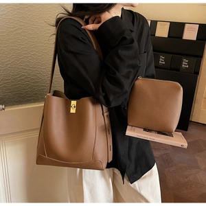 Détail du sac seau en cuir marron motif litchi avec fermoir doré élégant et pochette
