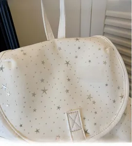 Detailed macro view of white twill canvas fabric with silver star patches and studs