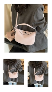 Detail of light pink half-moon bag featuring matte leather texture and elegant metal twist lock