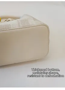 Detailed close-up of thickened reinforced base for stylish cream bucket handbag