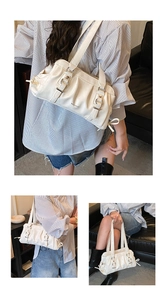 Close-up of pleated cream shoulder bag with silver buckles and side drawstring details