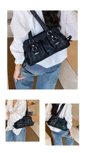 Detail of black pleated leather underarm bag featuring silver metal rings and double straps