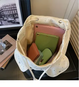 Top-down view of the large capacity interior of a star print white canvas backpack with items