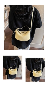 Close-up of yellow lychee grain leather bucket bag featuring a twist-lock and folded flap