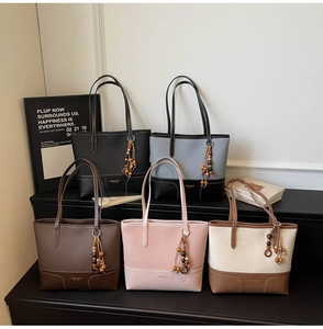 Detailweergave van diverse grote tote bags met decoratieve houten kralenkwastjes en stiksels
