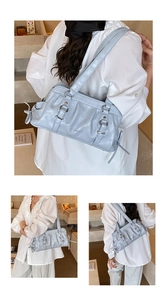 Detailed close-up of light blue leather shoulder bag with side bow ties and buckles
