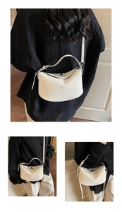 Detail of minimalist white leather bucket bag with silver metal buckle and soft texture