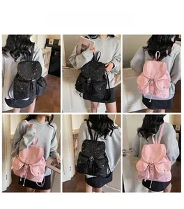 Detail view of star-patterned canvas backpacks in pink and black colors with metal buckles