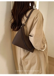 Detail showing deep brown lychee grain leather handbag with stylish chain and shoulder strap