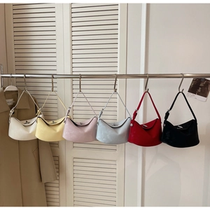 Detail of minimalist bucket bags with turn-lock hardware in six vibrant colors