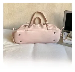 Detail view of pink wrinkled bag base with four silver metal protective bottom feet