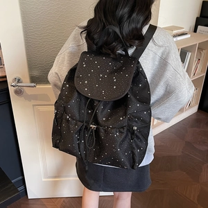 Detail of black star pattern backpack with drawstring closure and side pockets