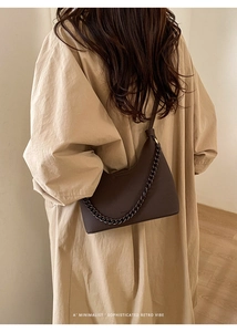 Deep brown lychee grain leather crescent bag with chain detail on a model