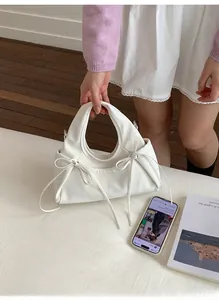 Dettaglio della borsa bianca a pieghe con fiocchi chic e consistenza in pelle morbida