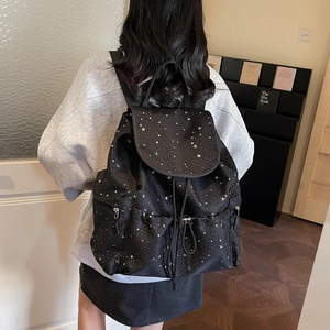 Detail view of black drawstring backpack with star pattern on adjustable straps