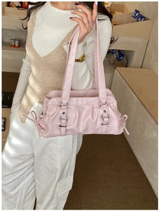 Pink pleated leather shoulder bag with buckle details and decorative side bow detail