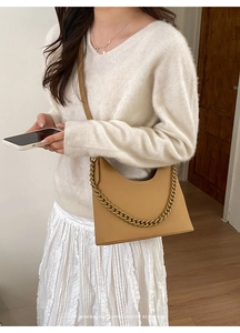 Detail of light brown lychee grain leather handbag with chunky gold chain and strap