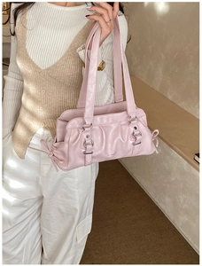Detail showing pink leather bag with pleated design and decorative silver metal buckle