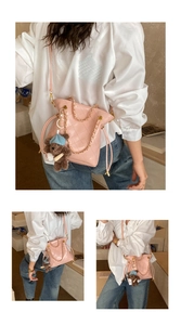 Detail of pink quilted bucket bag with gold chain strap and cute bear charm accessory