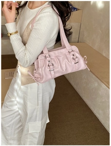 Detail view of pink shoulder bag with side drawstrings and elegant silver hardware