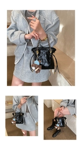 Close-up of black quilted bucket bag with chain strap and cute bear charm detail