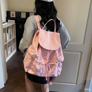 Lifestyle shot of pink drawstring backpack with star pattern and side pocket on a model