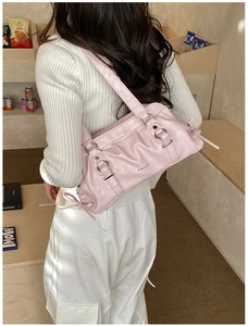 Detail of light pink pleated shoulder bag with silver buckle and decorative bows
