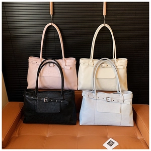 Detail of four colorful vintage tote bags with adjustable buckle straps and leather texture