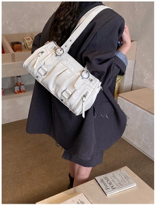Détail du sac à bandoulière en cuir verni blanc avec fermetures éclair Y2K et poches