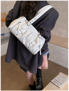 Detailaufnahme der weißen Lackleder-Tasche mit Falten-Design und silbernen Beschlägen