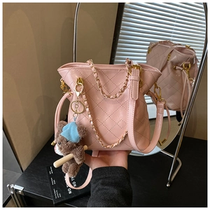 Pink quilted bucket bag detail with gold chain and cute brown plush bear charm