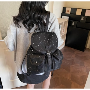 Detail view of black canvas star backpack with drawstring closure and side pockets