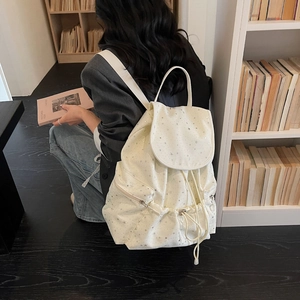 Polka dot drawstring backpack with silver star patterns on white canvas material