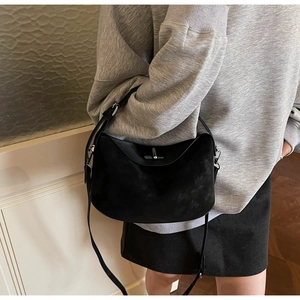 Close-up of black matte leather shoulder bag with silver metal swivel lock and strap detail