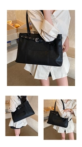 Detailed close-up of a large black tote bag with vintage belt buckle and leather texture
