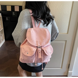 Pink canvas backpack with silver stars showing side view with flap and buckle details