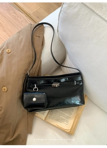 Detail einer schwarzen Leder-Beuteltasche im Vintage-Stil mit kleinem Anhänger-Etui