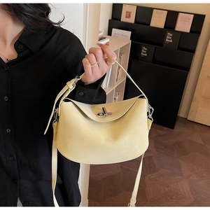 Detail shot of pale yellow minimalist bucket bag with silver rotating lock closure