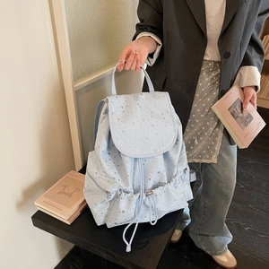 Close-up of light blue star-patterned backpack with drawstring and functional pockets
