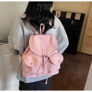 Detail view of the pink star canvas backpack featuring front metal snap pockets and drawstrings