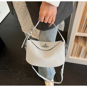 Detail view of the light grey bucket bag showing the unique folded design and metal swivel lock