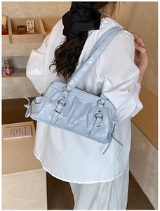 Detail of light blue pleated underarm bag with silver hardware and chic side tie design