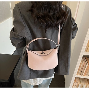 Detail view of pink half-moon shoulder bag with silver buckle and adjustable strap