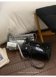Minimalistische silberne und schwarze Taschen mit Mini-Beuteln auf Holzboden
