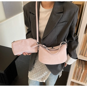 Detailed view of pink matte leather bucket bag set with silver buckles in casual setting