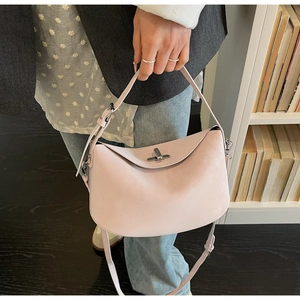 Close-up of pink bucket bag with silver metal twist lock and adjustable shoulder strap