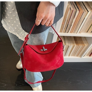 Detail of red suede shoulder bag with silver hardware and unique slouchy design
