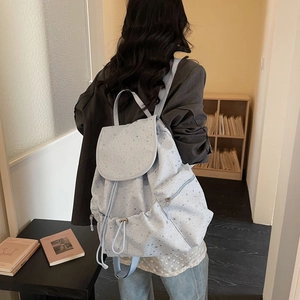 Close-up of a light blue starry backpack with drawstring and pockets in a school setting