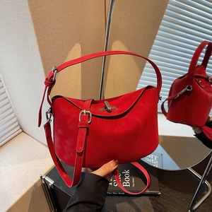 Chic red suede crescent bucket bag with adjustable strap and silver metal hardware